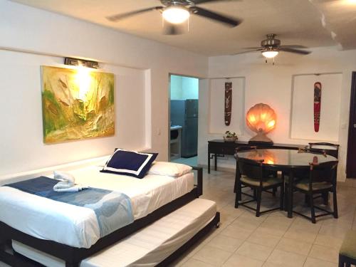 ein Schlafzimmer mit einem Bett und einem Tisch sowie ein Esszimmer in der Unterkunft Villa Guitarron gran terraza vista espectacular 6 huespedes piscina gigante in Acapulco