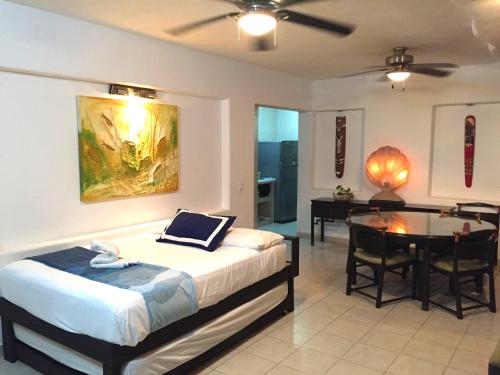 a bedroom with a bed and a desk and a table at Villa Guitarron gran terraza vista espectacular 6 huespedes piscina gigante in Acapulco
