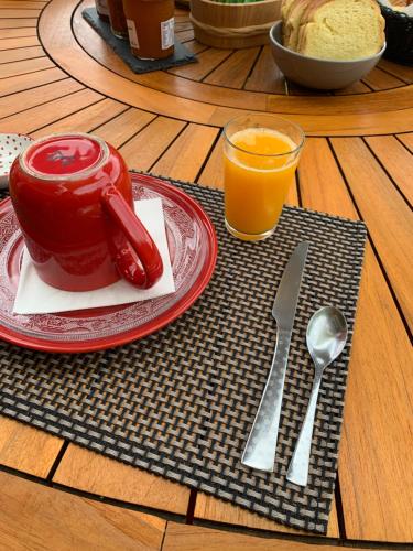 a table with a plate of food and a glass of orange juice at Chambre d'hôtes Le Clos 67 in Saint-Paul-de-Vence
