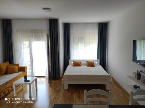 a living room with a bed and a couch at Comfort studio with sea view and swimming pool in Becici