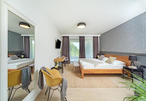 Cette chambre d'hôtel comprend deux lits, une table et des chaises. dans l'établissement B&B Plitvice Lacus, à Selište Drežničko