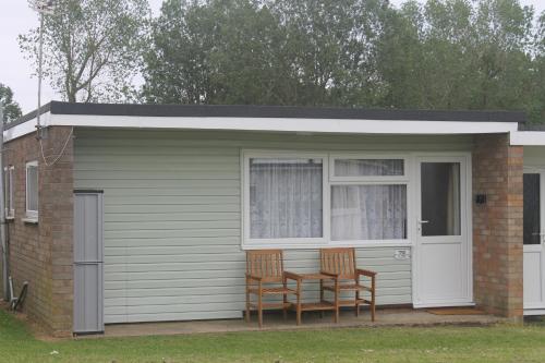 two chairs and a table in a shed at 78 Florida Holiday Park in Hemsby