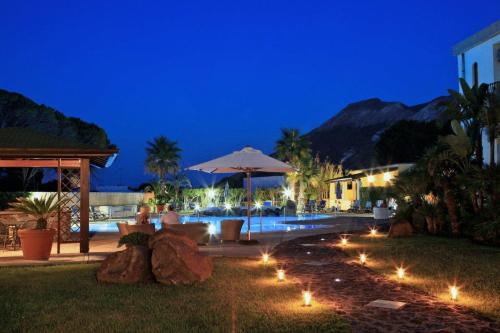 a backyard with a pool at night with lights at Hotel Orsa Maggiore in Vulcano