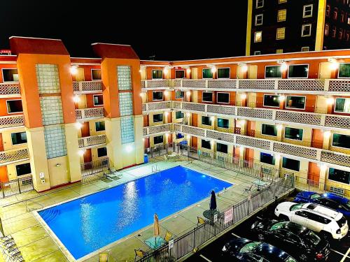 a large building with a large swimming pool in front of it at Clarion Inn Atlantic City in Atlantic City