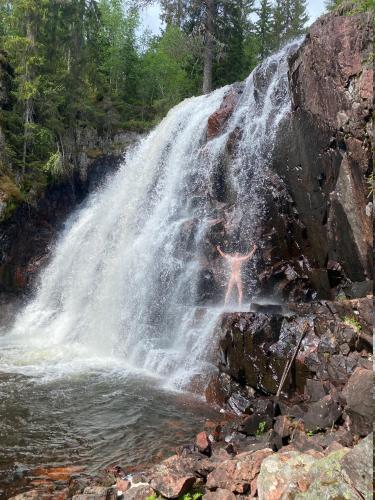 a person standing in front of a waterfall at Prinsgården B&B rum stugor in Mora
