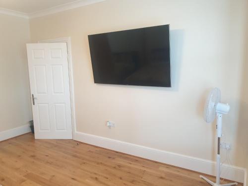 a room with a flat screen tv on a wall at London Luxury Apartments 5 min walk from Ilford Station, with FREE PARKING FREE WIFI in Ilford