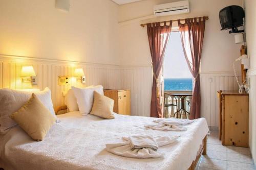 a hotel room with a bed with towels on it at Sunrise in Kokkari