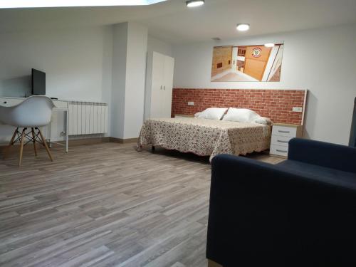 sypialnia z łóżkiem i ścianą z cegły w obiekcie Edificio Valles del Lúpulo (DUPLEX) w mieście Astorga