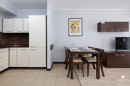 uma cozinha e sala de jantar com mesa e cadeiras em Jantar Apartamenty - AQUARIUS Apartamenty em Kolobrzeg