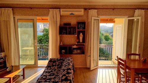 een kamer met een bed, een tafel en een balkon bij AGATHA'S HOUSE in Kouspádes