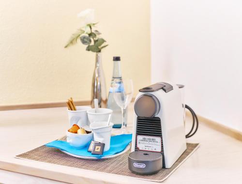 a coffee maker sitting on a table next to a blender at Hotel Restaurant Kerzenstüble in Gärtringen