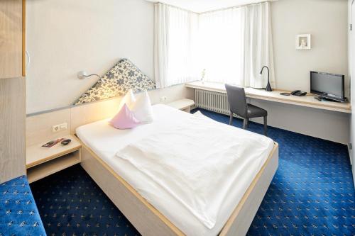 a hotel room with a bed and a desk at Hotel Restaurant Kerzenstüble in Gärtringen