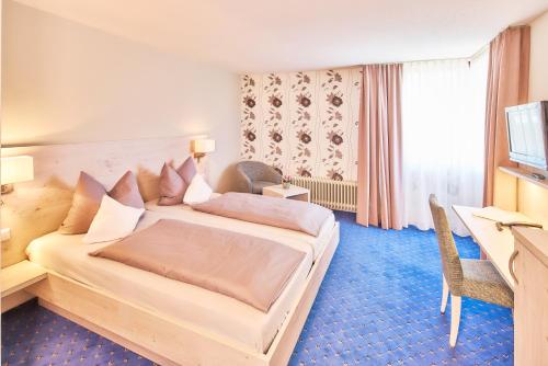 a hotel room with a bed and a desk at Hotel Restaurant Kerzenstüble in Gärtringen