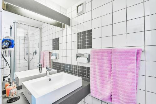 a bathroom with a sink and a pink towel at Hotel Restaurant Kerzenstüble in Gärtringen