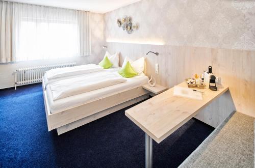 a bedroom with a large bed and a table at Hotel Restaurant Kerzenstüble in Gärtringen