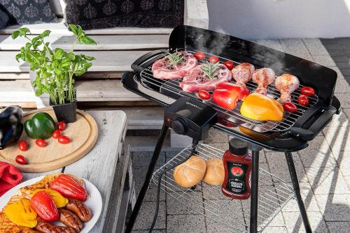 a grill with meat and vegetables and a plate of food at Home apartment Turku in Turku