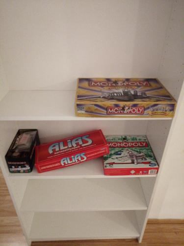 uma prateleira com alguns jogos e outros itens sobre ele em Home apartment Turku em Turku