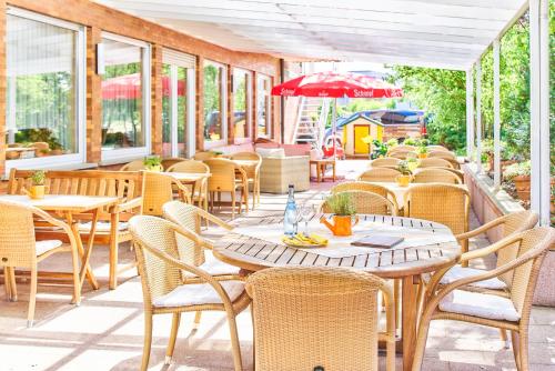 an outdoor patio with tables and chairs and windows at Hotel Restaurant Kerzenstüble in Gärtringen
