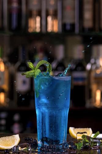 a blue drink with a green plant in it at GasthauS & SPA in Bukovel