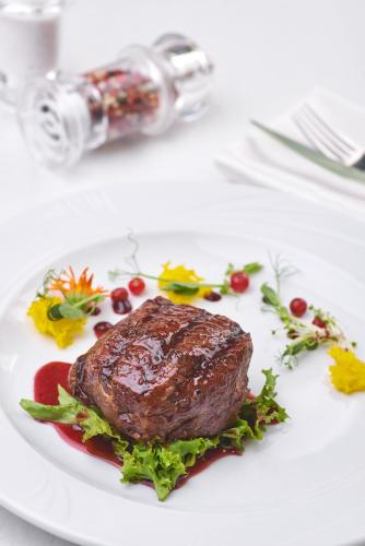 a plate of food with a piece of meat on a table at GasthauS & SPA in Bukovel
