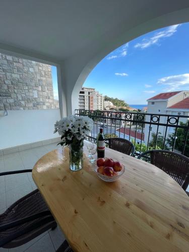 a table with a bottle of wine and a bowl of fruit at Villa Mila in Petrovac na Moru