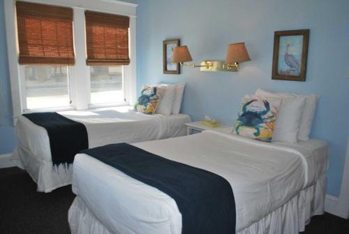 two beds in a room with blue walls at Lankford Hotel and Lodge in Ocean City