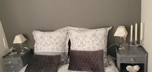 a bedroom with a bed with two night stands and two pillows at Hôtel restaurant du Commerce in Poulainville