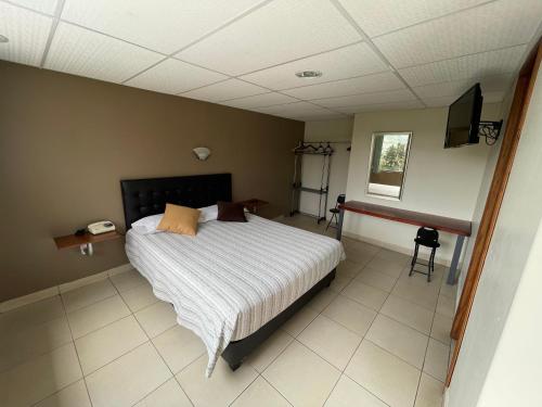 a bedroom with a bed and a television in it at El Balcon de los Reyes in Ibarra