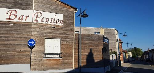 a building with a bar extension sign on the side of it at Hôtel restaurant du Commerce in Poulainville