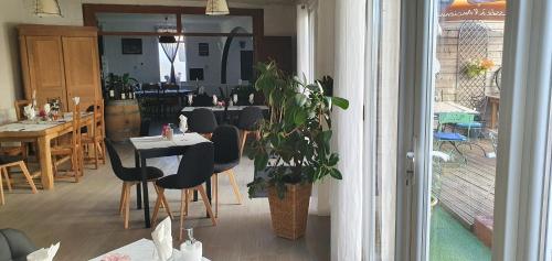 a restaurant with a table and chairs and a plant at Hôtel restaurant du Commerce in Poulainville