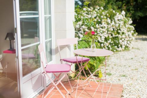 a table with two chairs and a table with a vase of flowers at La Tour de la Conterie in Beaumont-Village