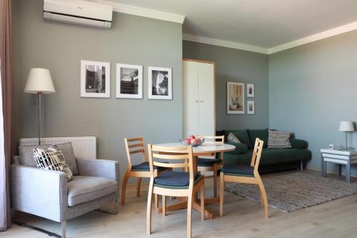 sala de estar con mesa, sillas y sofá en Vita Apartmanok, en Hévíz