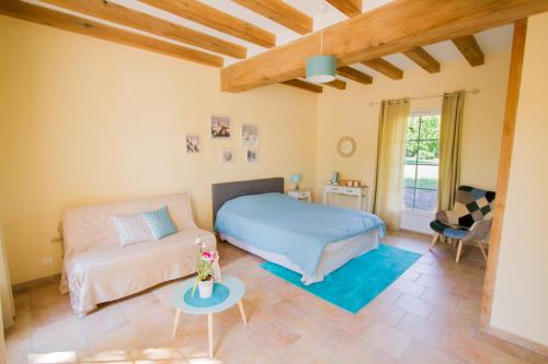 a bedroom with a bed and a couch and a table at La Tour de la Conterie in Beaumont-Village