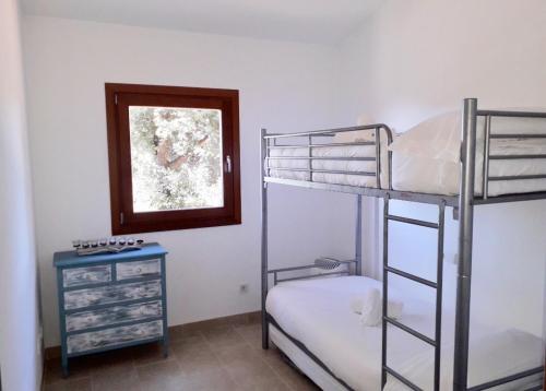 a bedroom with two bunk beds and a dresser at Sa Talaia in Lluc