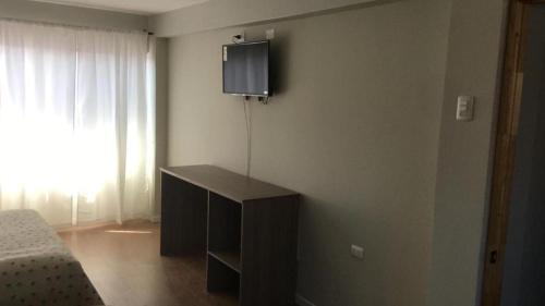 a bedroom with a bed and a tv on the wall at Hotel Amaru Express in Arica