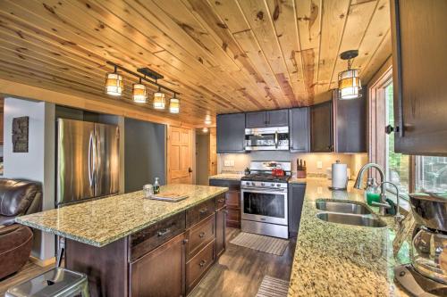 a kitchen with wooden cabinets and a counter top at Loon Lake Lodge with Dock, Sauna and Hot Tub! in Pequot Lakes