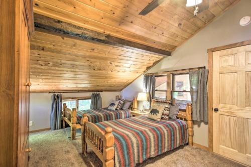 two beds in a room with wooden ceilings at Loon Lake Lodge with Dock, Sauna and Hot Tub! in Pequot Lakes