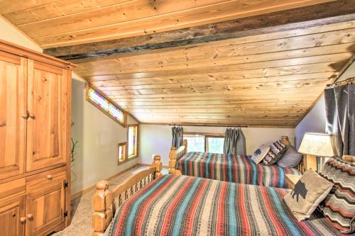 two beds in a bedroom with wooden ceilings at Loon Lake Lodge with Dock, Sauna and Hot Tub! in Pequot Lakes