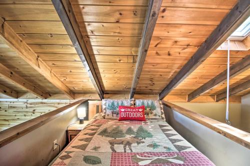 a bed in a tiny house with wooden ceilings at Loon Lake Lodge with Dock, Sauna and Hot Tub! in Pequot Lakes