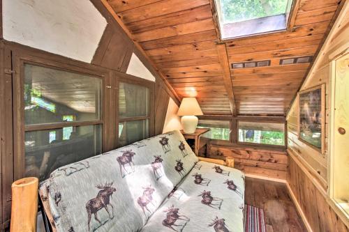 a room with a bed in a cabin with wooden walls at Loon Lake Lodge with Dock, Sauna and Hot Tub! in Pequot Lakes