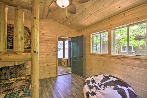 a log cabin with a bed and a ceiling fan at Loon Lake Lodge with Dock, Sauna and Hot Tub! in Pequot Lakes