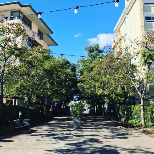 a street with trees and benches in front of a building at Impecable Loft en Nordelta Bahía in Benavídez