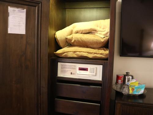 a room with a closet with a microwave and a tv at Camino Real Antigua in Antigua Guatemala