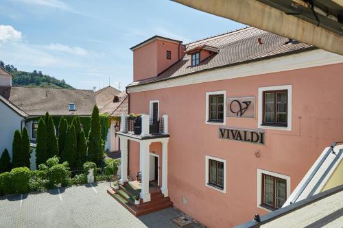 a view of a pink building with a sign on it at Vivaldi Apartments in Mikulov