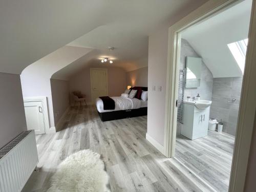 a bedroom with a bed and a bathroom with a mirror at Drumlanaught Cottage Farnham in Cavan