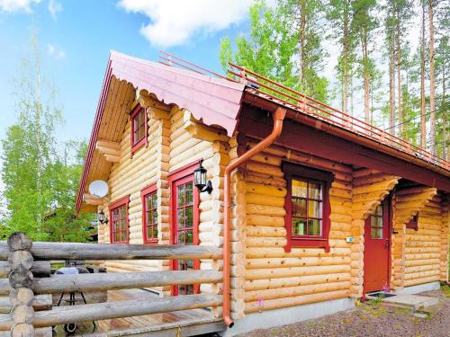 a log cabin with a pink roof and a fence at 6 person holiday home in SÄLEN-By Traum in Tandådalen