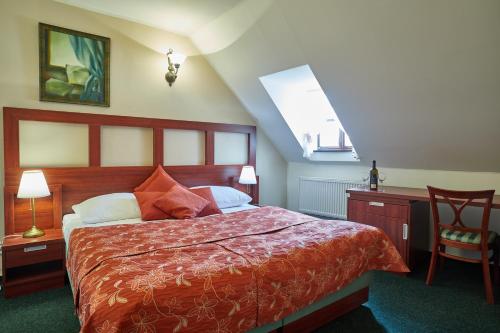 a bedroom with a bed and a desk and a window at Vivaldi Apartments in Mikulov