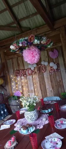 a table with plates and flowers on top of a wooden wall at Siedlisko Józefka in Zaróbka