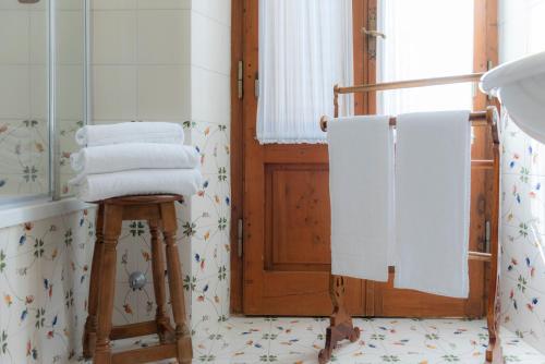 a bathroom with a stack of towels on a stool at Villa Scacciapensieri Boutique Hotel in Siena