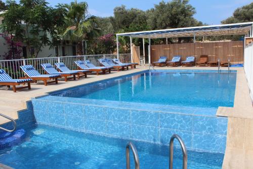 a swimming pool with lounge chairs next to at Patara Caretta Hotel in Patara
